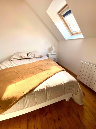 une chambre avec un lit et une lucarne dans l'établissement Évasion dans le Golfe du Morbihan, à Arradon