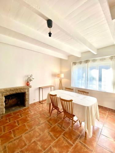 une salle à manger avec une table et des chaises et une cheminée dans l'établissement Évasion dans le Golfe du Morbihan, à Arradon