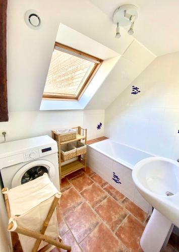 une salle de bain avec une machine à laver et un lavabo dans l'établissement Évasion dans le Golfe du Morbihan, à Arradon