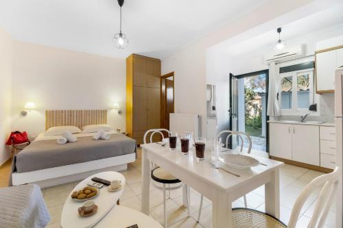 a bedroom with a bed and a table and a kitchen at Dionysia Rooms in Lefkada