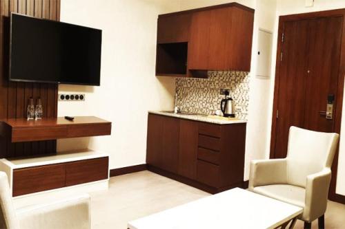 a living room with a television and a kitchen at Imperial Plaza Hotel, Juba in Juba