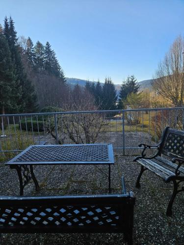 two benches sitting in front of a fence at Triberg Falls Hideaway - Apartment 35 in Triberg