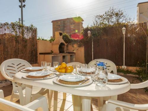 a white table with plates and bowls of fruit on it at Holiday Home Boters-2 by Interhome in Torredembarra