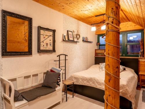 a bedroom with a bed and a chair in a room at Chalet Srub Pohodář by Interhome in Benešov nad Černou