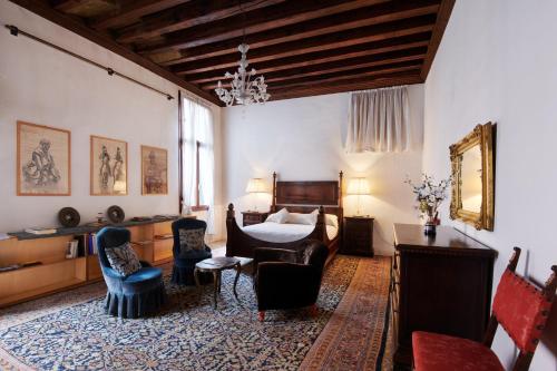 a bedroom with a bed and a table and chairs at Palazzo Contarini Della Porta Di Ferro in Venice