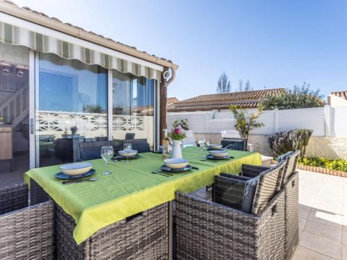 une table avec un tissu de table jaune sur une terrasse dans l'établissement Holiday Home Les Ondines 1 by Interhome, au Cap d'Agde