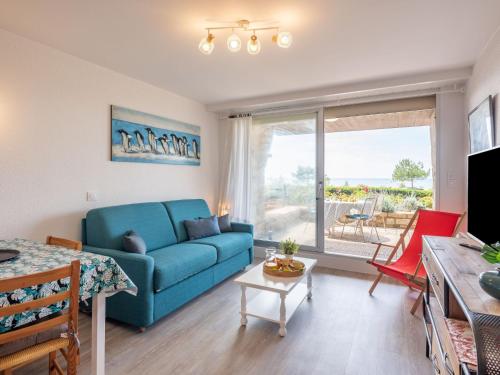 un salon avec un canapé bleu et une table dans l'établissement Studio Le Britannia-2 by Interhome, à Carnac