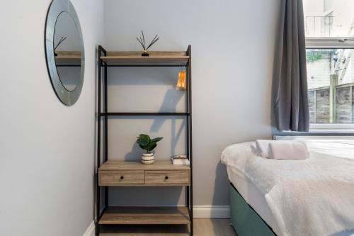 a bedroom with a mirror and a shelf next to a bed at Wembley Haven - 2 Bdr - Sleeps 9 in London