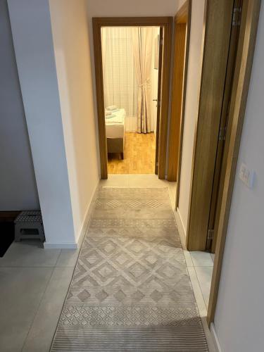 un corridoio con una porta che conduce a una camera da letto di Emel Apartman a Ulcinj