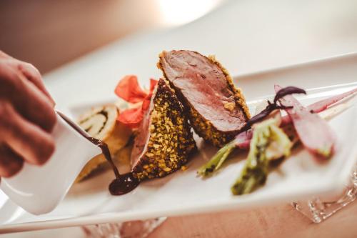 a person eating a plate of food on a table at Simon - das Vitalhotel in Bad Tatzmannsdorf
