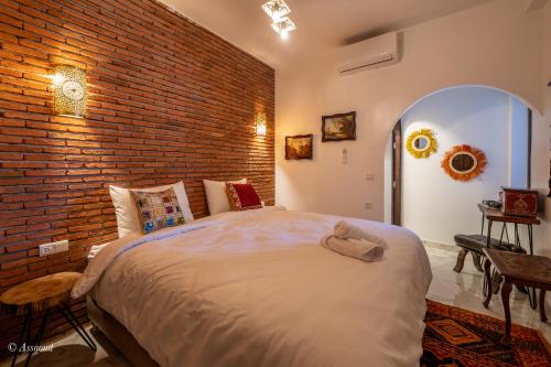 a bedroom with a large bed with a brick wall at Casa maravillosa in Chefchaouene