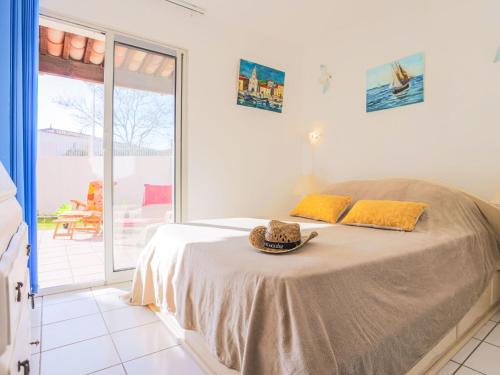 une chambre avec un lit avec un chapeau dessus dans l'établissement Apartment Domaine Grand Plage by Interhome, au Cap d'Agde