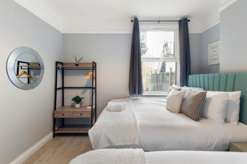 a bedroom with a bed with a mirror and a window at Wembley Haven - 2 Bdr - Sleeps 9 in London