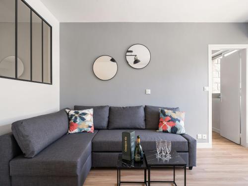 - un salon avec un canapé gris et deux miroirs dans l'établissement Apartment Le Triskel by Interhome, à Dinard