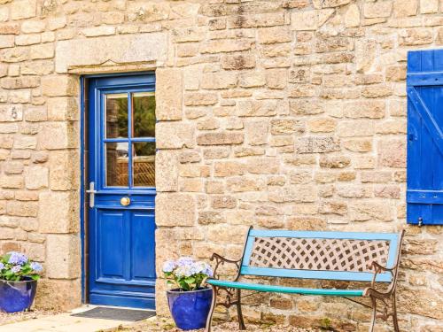 une porte bleue et un banc devant un bâtiment dans l'établissement Holiday Home Maison de Kerguen by Interhome, à Ploemeur