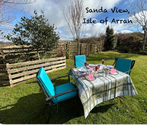 a table with blue chairs and a table cloth at Sanda View, Isle of Arran in Sliddery