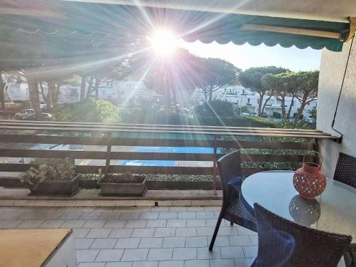 - un balcon avec une table et des chaises offrant une vue sur le soleil dans l'établissement Apartment Les Villégiales Tee1 by Interhome, à La Grande Motte