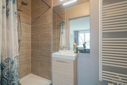 une salle de bain avec un lavabo et une douche dans l'établissement Modern, parking, downtown, 20 minutes from Paris, à Argenteuil