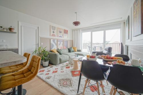 un salon avec un canapé et une table avec des chaises dans l'établissement Modern, parking, downtown, 20 minutes from Paris, à Argenteuil