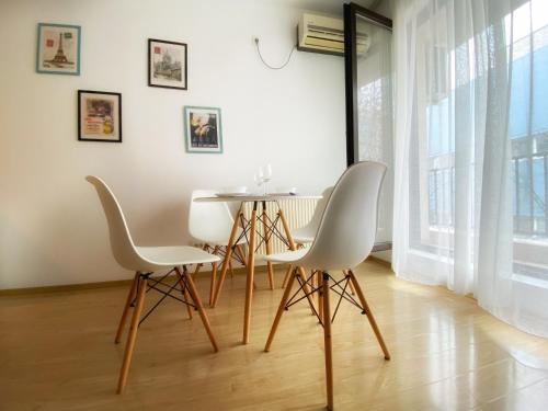 a dining room with white chairs and a table at Musetesti Residential in Bucharest
