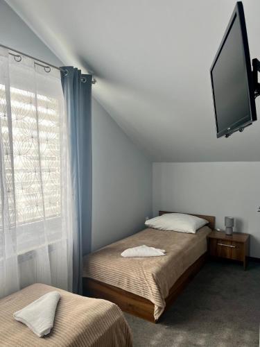 a bedroom with two beds and a flat screen tv at Hotel Paola in Kraczkowa