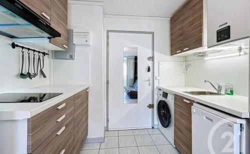 une cuisine avec un évier et une machine à laver dans l'établissement raisins d'or 2 avenue du surintendant cap d'agde, au Cap d'Agde