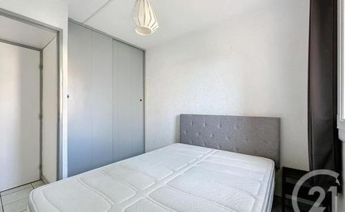 une chambre avec un lit blanc dans une pièce dans l'établissement raisins d'or 2 avenue du surintendant cap d'agde, au Cap d'Agde
