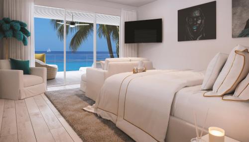 a bedroom with two white beds and a living room at Solaris Beach House - Beachfront Property, St James in Saint James