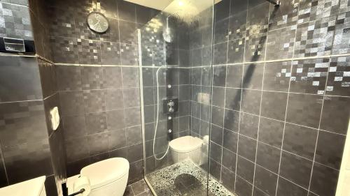 La salle de bains est pourvue de toilettes et d'une horloge murale. dans l'établissement Les Terrasses du Juana, à Antibes