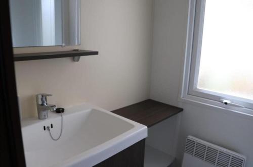 une salle de bain avec un lavabo blanc et une fenêtre dans l'établissement MH 395 3 chambres et 1 salle de bain dans camping 4 étoiles, à Saint-Julien-en-Born