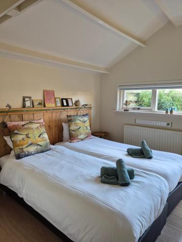 a large bed with two pairs of shoes on it at B&B De Wadvaarder in Midsland