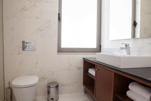 a bathroom with a white toilet and a sink at Andon Lapa Hotel & Spa in Sarandë