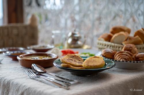 a table topped with plates of bread and pastries at Casa maravillosa in Chefchaouene