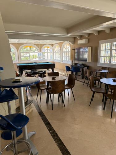 a room with tables and chairs and a pool table at Amaca in Mijas Costa