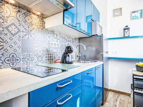 La cuisine bleue est équipée d'un évier et d'un réfrigérateur. dans l'établissement Apartment Ajoupa-6 by Interhome, à Canet