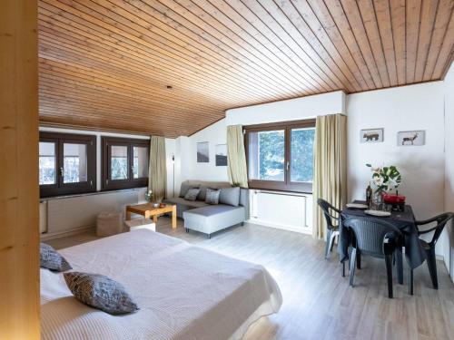 a bedroom with a bed and a table and a desk at Apartment Gamat 49 by Interhome in Villars-sur-Ollon