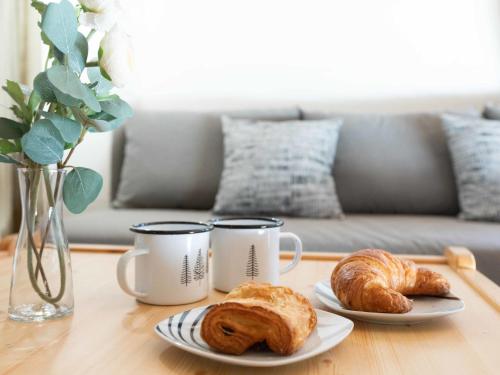 twee kopjes en twee croissants op een tafel bij Apartment Gamat 49 by Interhome in Villars-sur-Ollon
