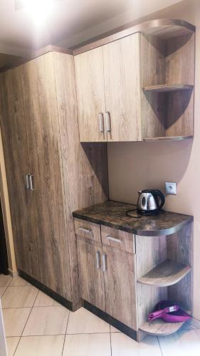 a kitchen with wooden cabinets and a bowl on the counter at Kompleks Rekreacyjno-Wypoczynkowy i Restauracja STRUMYK in Jordanów