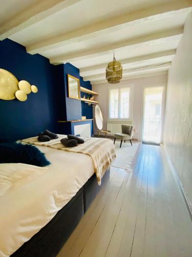 une chambre avec un grand lit et un mur bleu dans l'établissement Esprit Nomad - Appartement rue piétonne proche lac, à Annecy