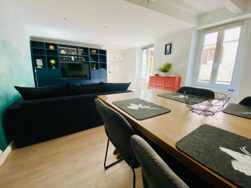 un salon avec une table et un canapé dans l'établissement Esprit Nomad - Appartement rue piétonne proche lac, à Annecy