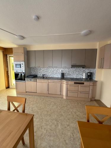 a large kitchen with white cabinets and a table at Apartment Natali in Schnaittenbach