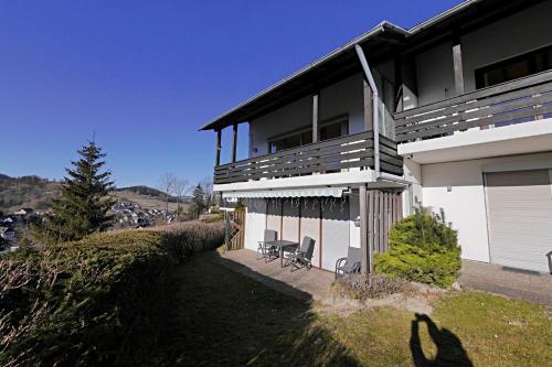 a house with two chairs sitting outside of it at Ferienwohnung Schöner Ausblick in Willingen