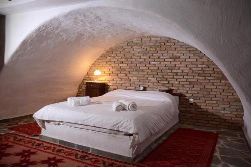 a bedroom with a bed in a brick wall at Villa Katerinas in Magoúliana