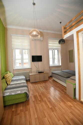 una camera da letto con due letti e una TV a schermo piatto di Apartments Downtown Novi Sad a Novi Sad