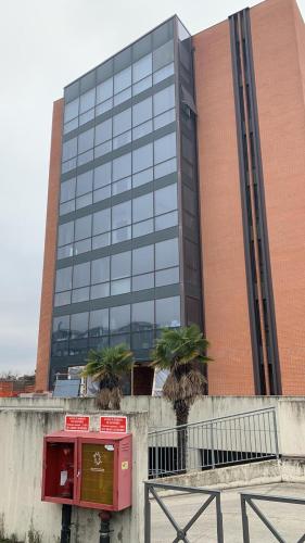a large glass building with palm trees in front of it at Cozy Nest in Bologna