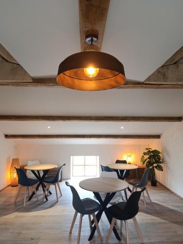 une salle à manger avec des tables, des chaises et un éclairage dans l'établissement Chambres au Fort la Prée, à La Flotte