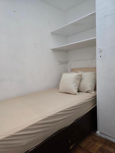 a bed in a room with two pillows on it at apartment cool & seafront Arpoador in Rio de Janeiro