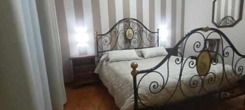 a bedroom with a bed with a wrought iron headboard at Villa Cristina in Boissano