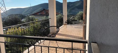 a bench on a balcony with mountains in the background at Villa Cristina in Boissano