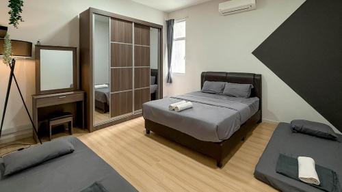 Taiping Chill Retreat Homestay near Lake Garden في تايبينغ: غرفة نوم بها سرير كبير ومرآة